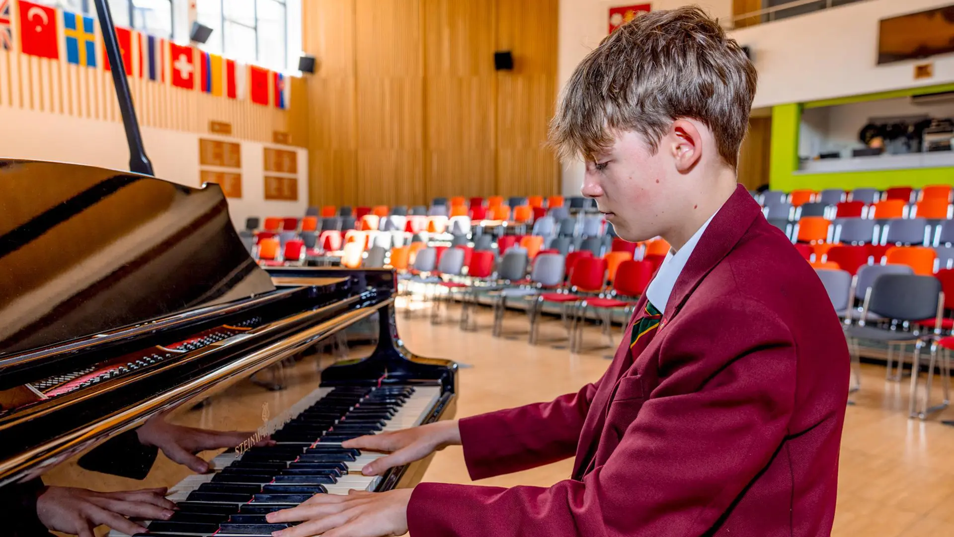 alumno en clase de musica tocando el piano en el curso escolar en Inglaterra de Ashville College