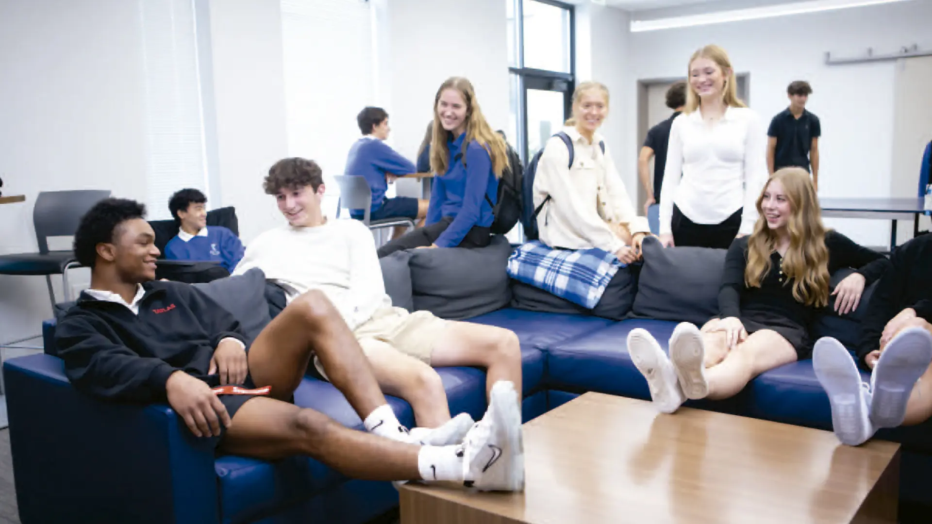 alumnos y alumnas socializando en la zona comun de sofas de la residencia en el curso escolar en estados unidos en Cotter Schools