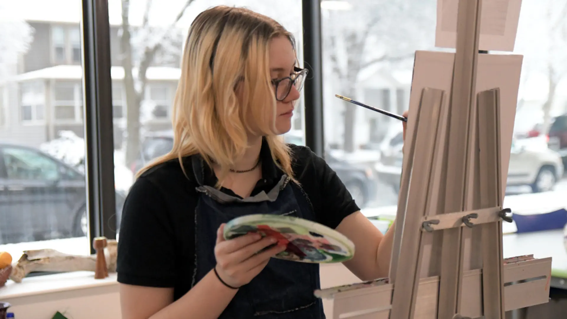 alumna de arte pintando un cuadro en el curso escolar en estados unidos en Cotter Schools