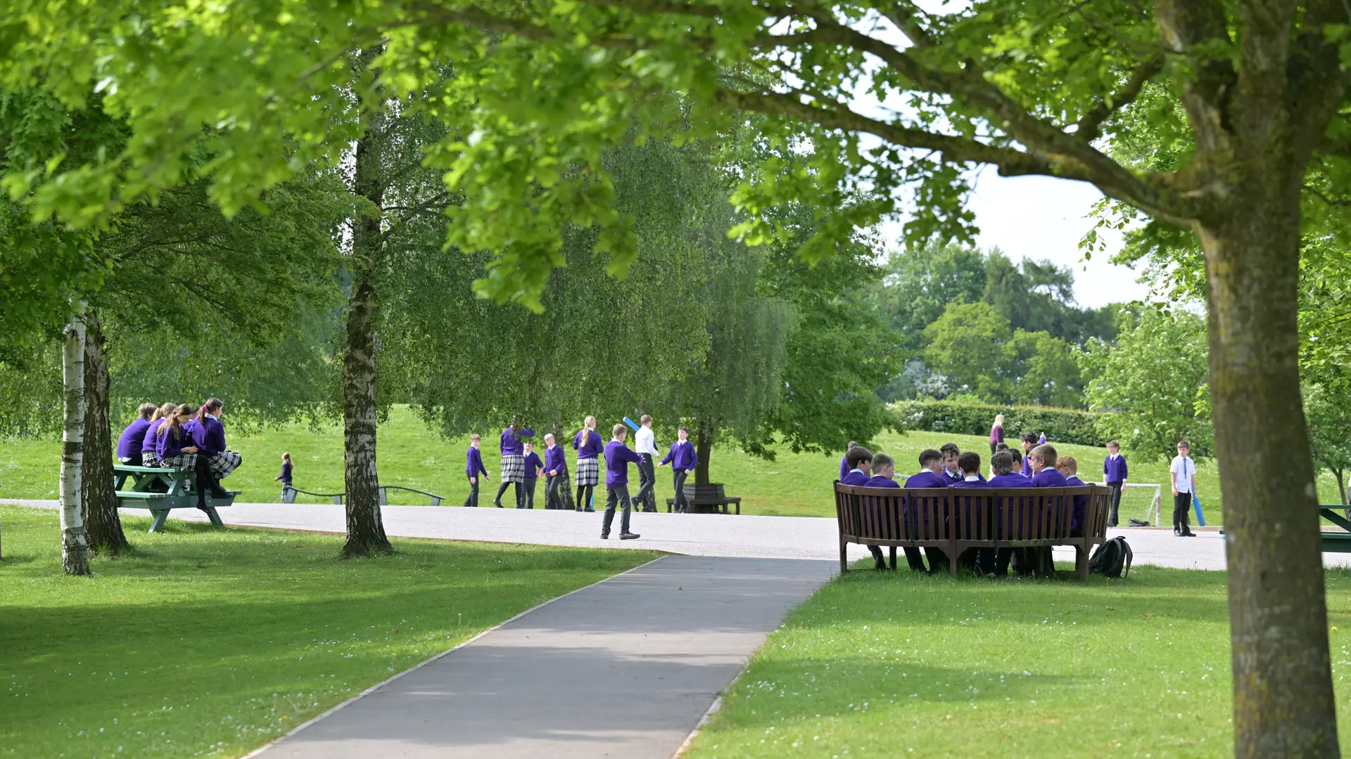 alumnos disfrutando del césped y bancos al aire libre del campus en el curso escolar en inglaterra en Ellesmere College