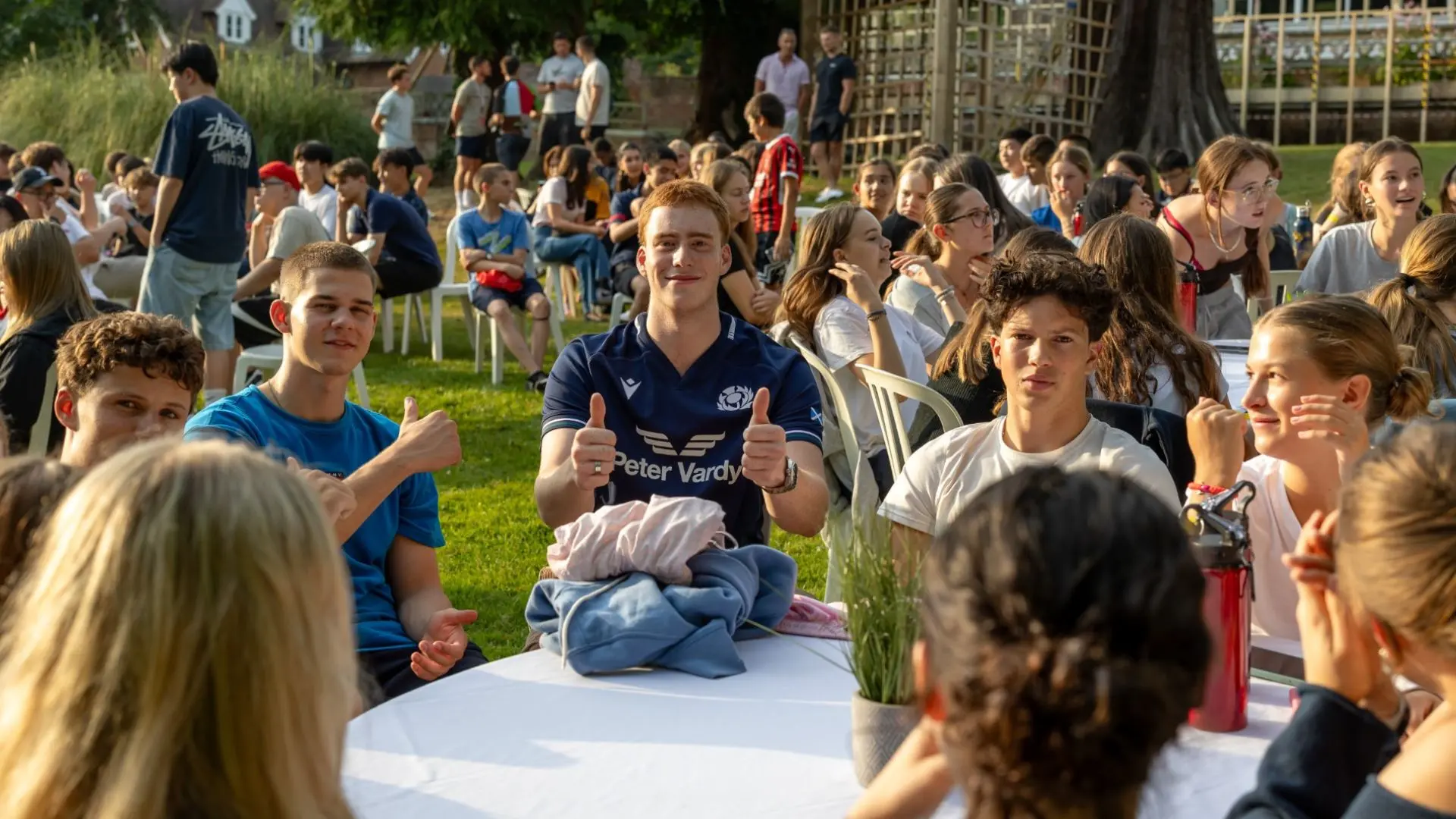 alumnos en el cesped del campus realizando una celebración en el curso escolar en inglaterra en Kent College
