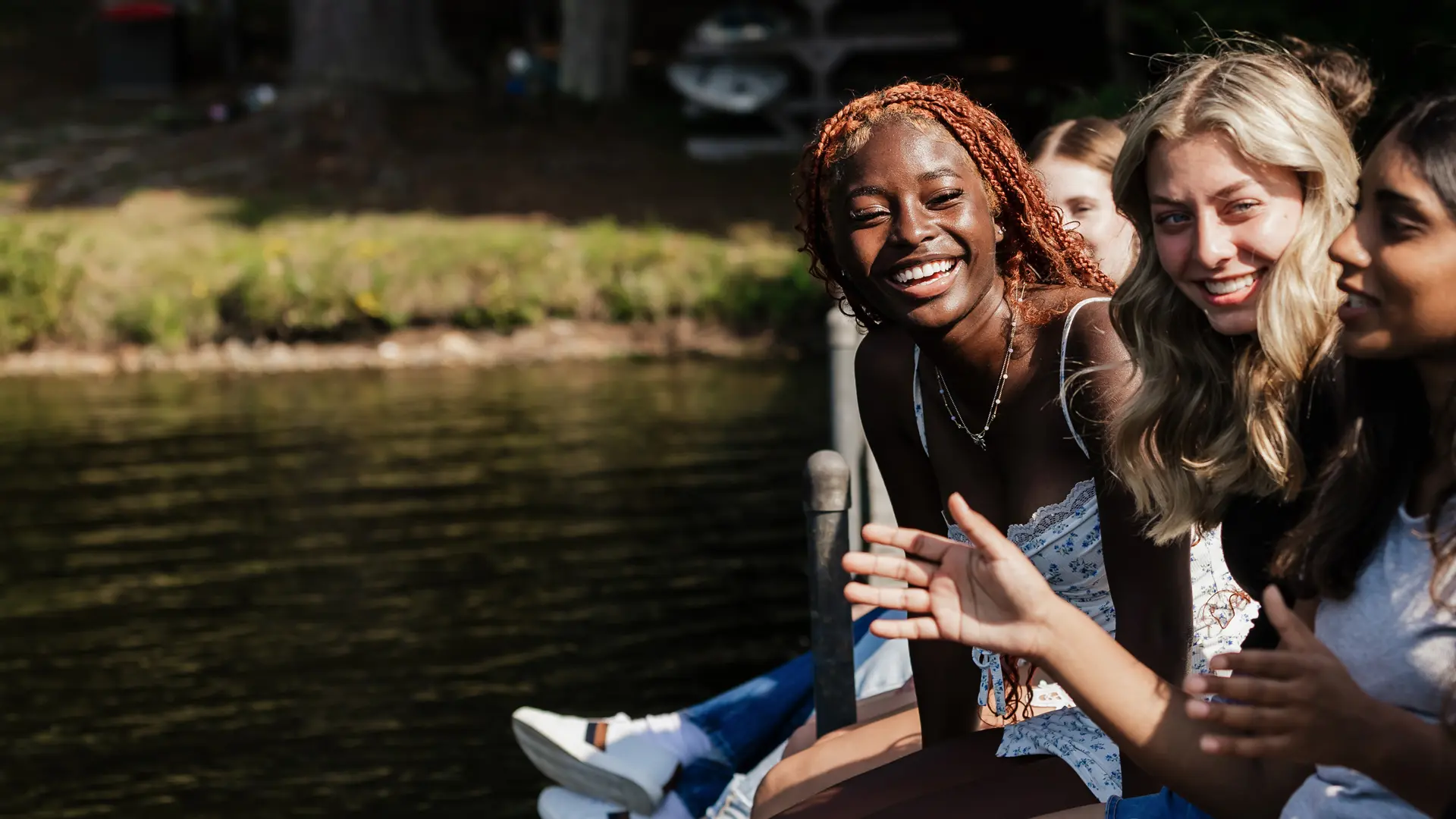alumnas hablando al borde del lago en el curso escolar en estados unidos en Kents Hill School