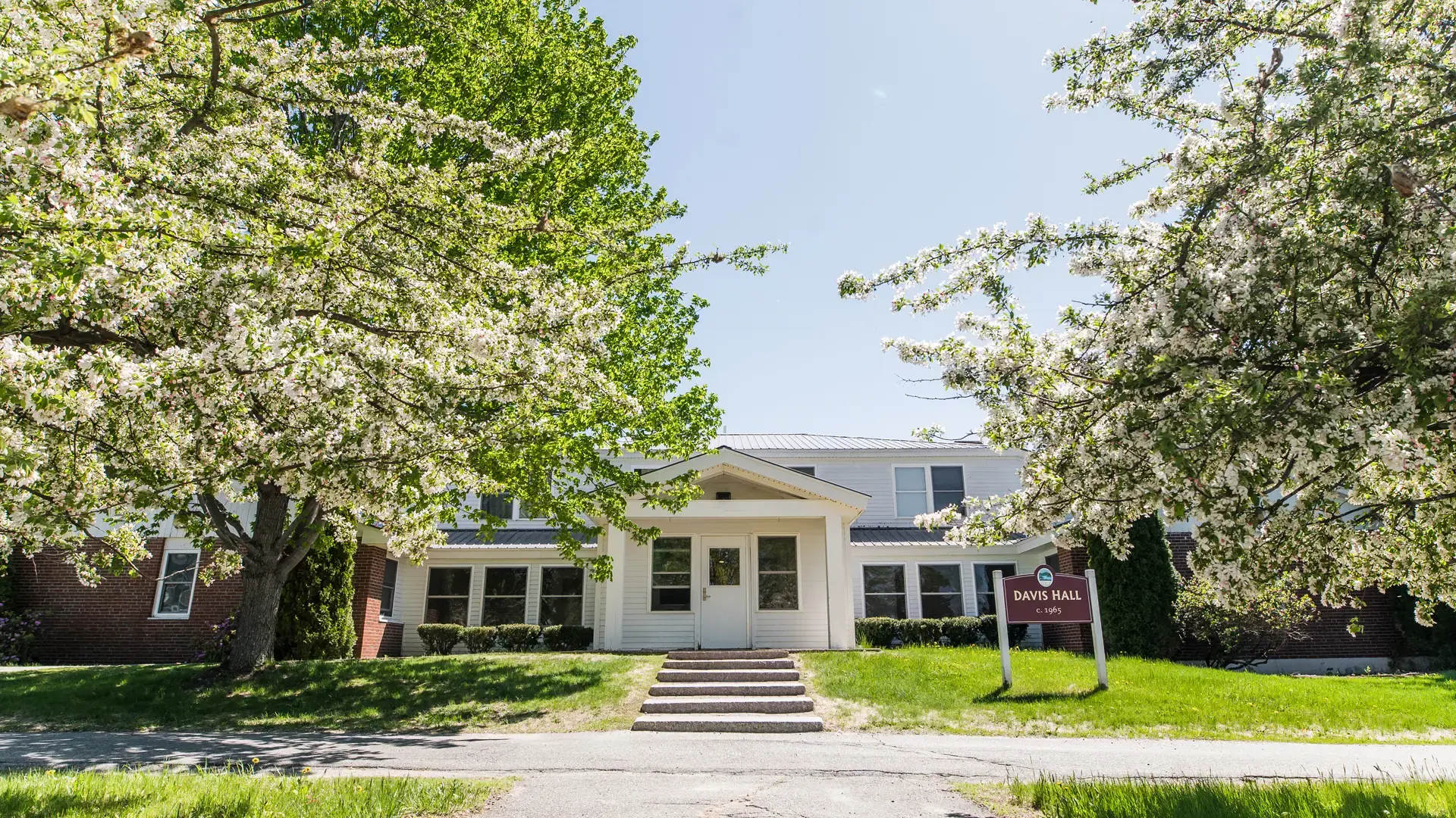 edificio con arboles florecidos en primavera en el curso escolar en estados unidos en Kents Hill School