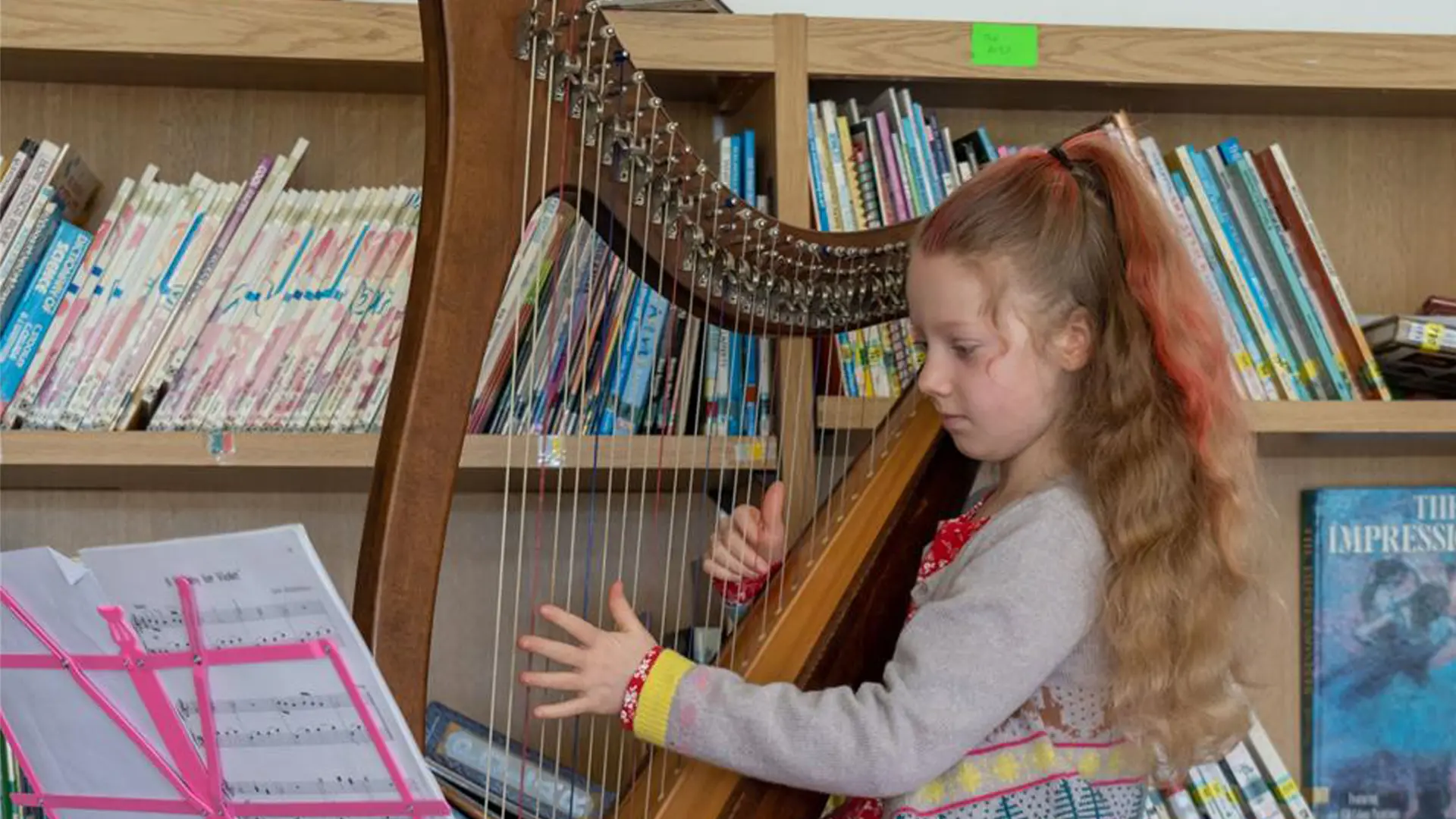 alumna tocando el arpa en clase de musica en el curso escolar en inglaterra en Kingsley School Bideford