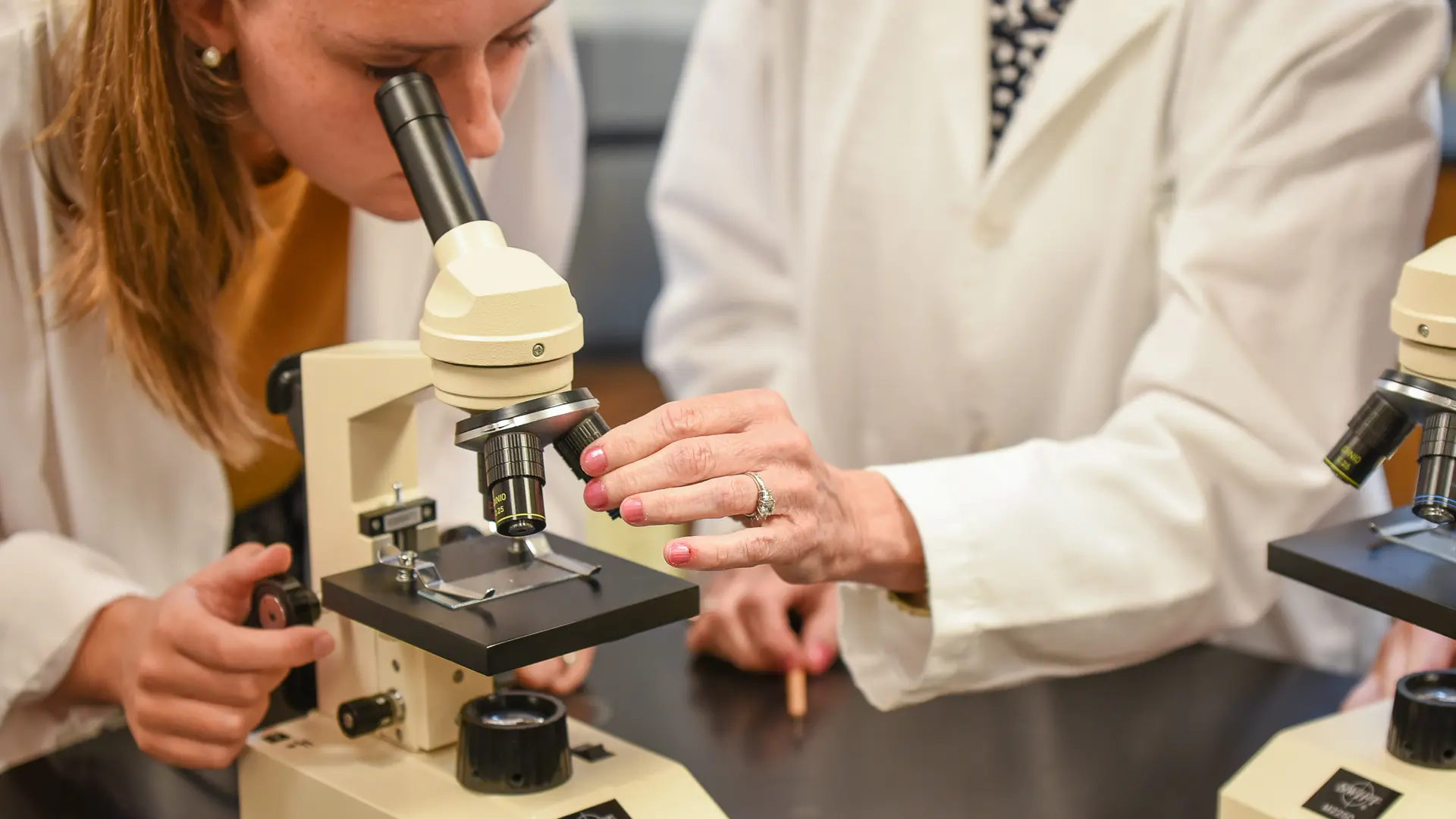 alumna en el laboratorio de ciencias con un microscopio en el curso escolar en estados unidos de Norfolk Christian Schools