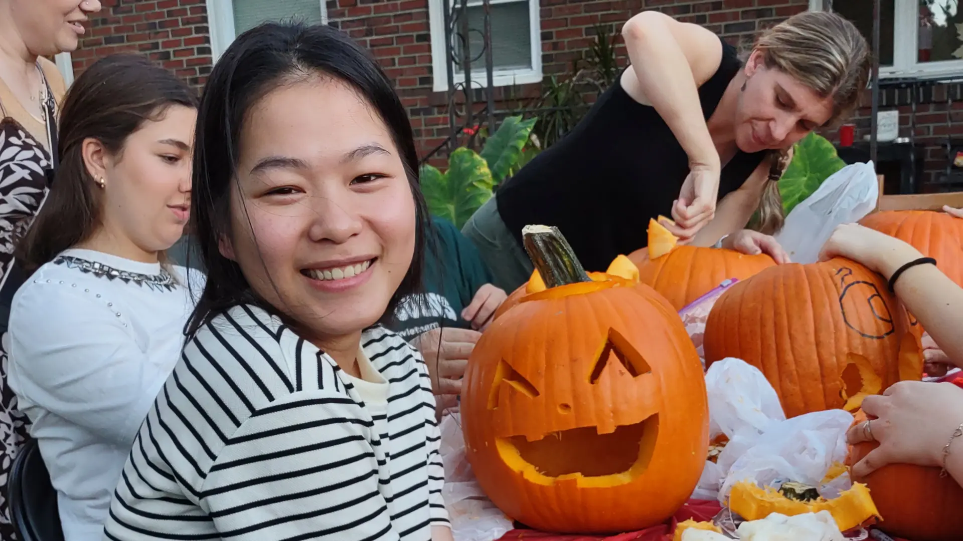 alumnas tallando calabazas para Halloween en el curso escolar en estados unidos de Norfolk Christian Schools
