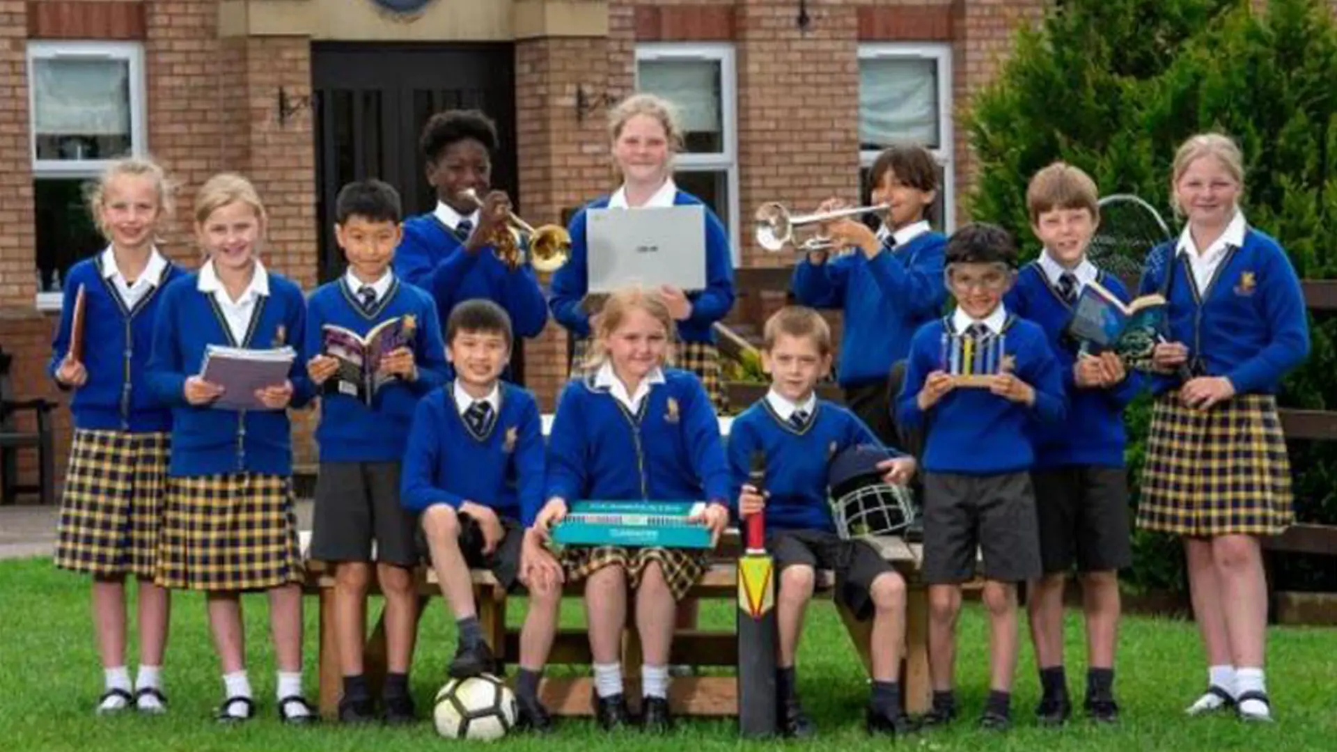 alumnos con instrumentos y distintos libros que muestran las opciones extraescolares disponibles en el curso escolar en inglaterra en Queen’s College