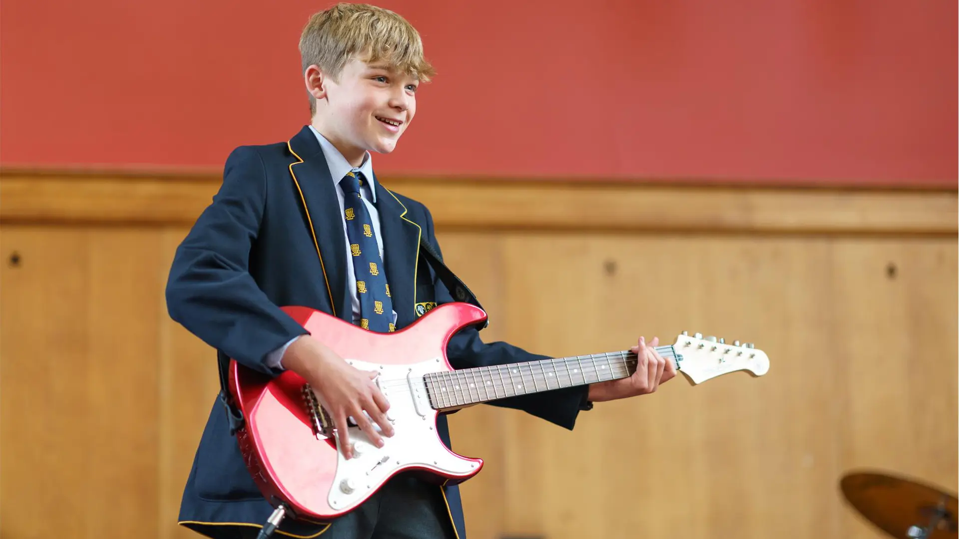 alumno tocando la guitarra en clase de musica en el curso escolar en inglaterra en Ratcliffe College