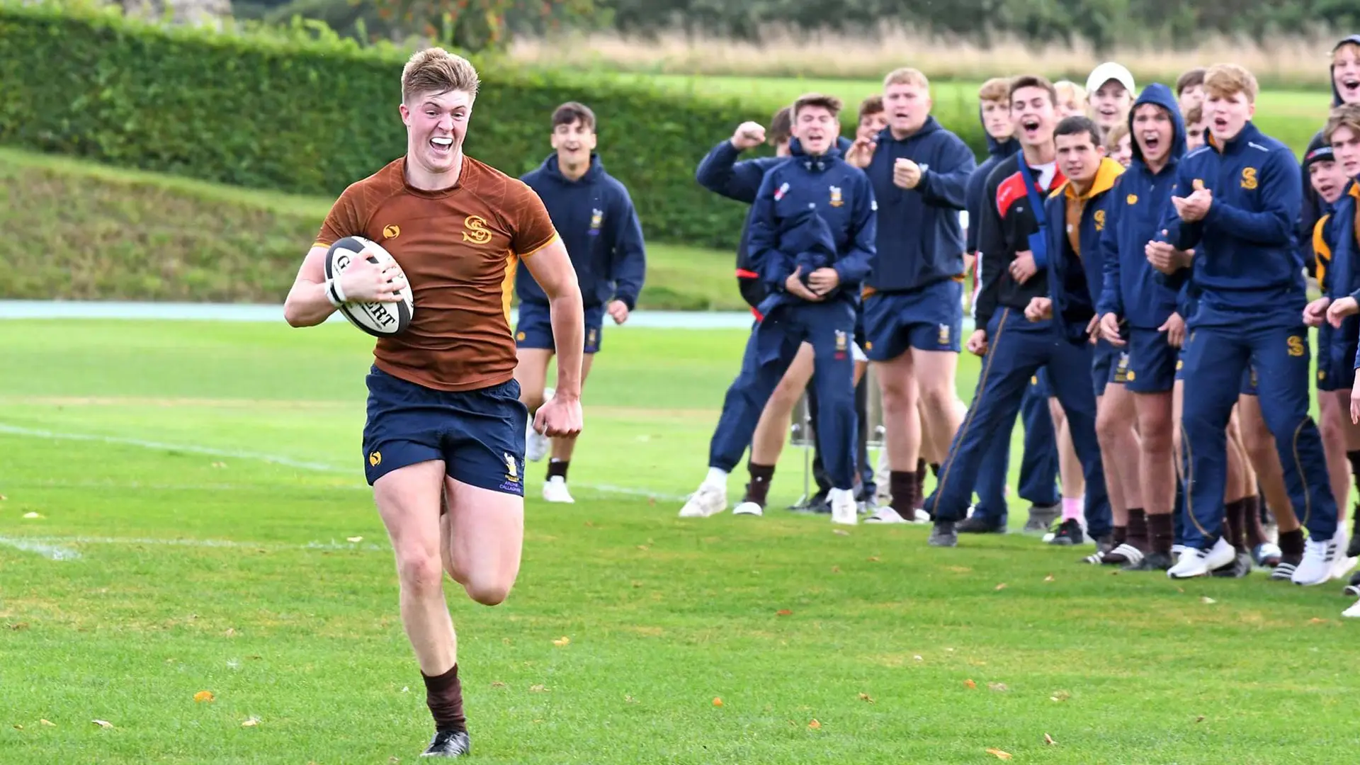 alumnos jugando a rugby masculino en el campo del colegio en el curso escolar en inglaterra en Sedbergh School