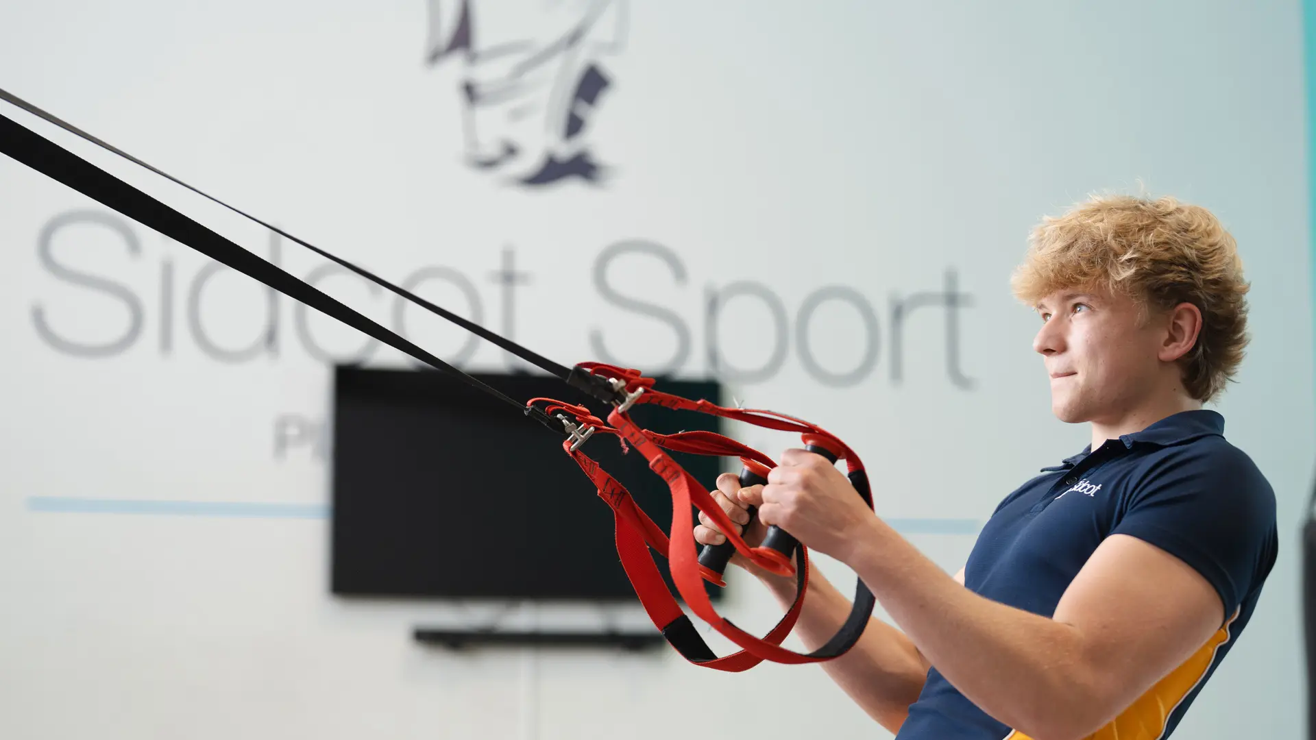 alumno practicando trx en las instalaciones del gimnasio en el curso escolar en inglaterra en Sidcot School