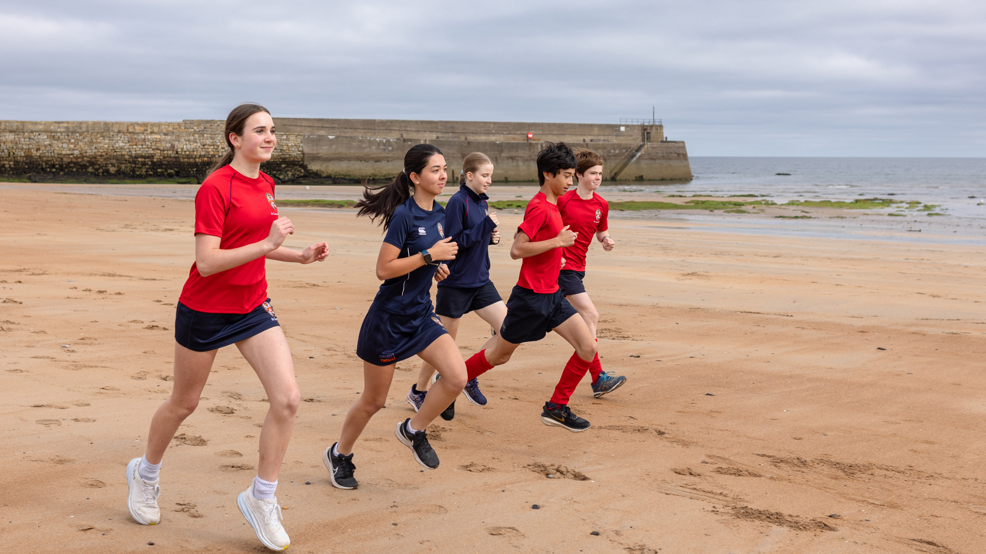 alumnos haciendo running por la playa en el curso escolar en inglaterra en St. Leonards School